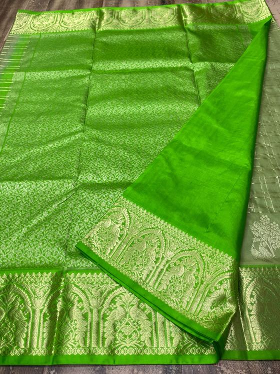 Leaf green silk saree with all-over gold brocade and arched peacock border